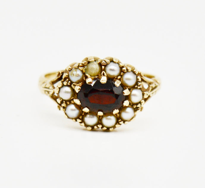Victorian 9ct gold ring inset with garnet flanked by seed pearls